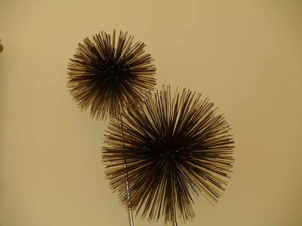 An arrangement of three pom-pom from large (starting on the bottom) to small to go with a chrome base with an embedded light.