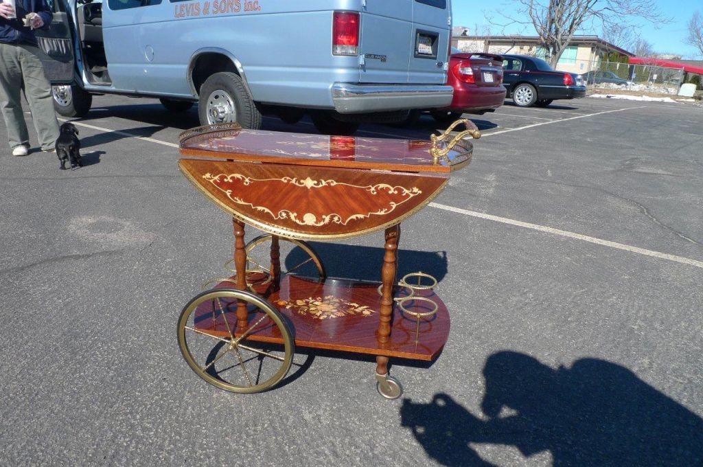 Gorgeous lacquered marquetry Italian bar cart / serving trolley with brass gallery, wheels and bottle fittings. Side wings open up to form large oval tray surface.