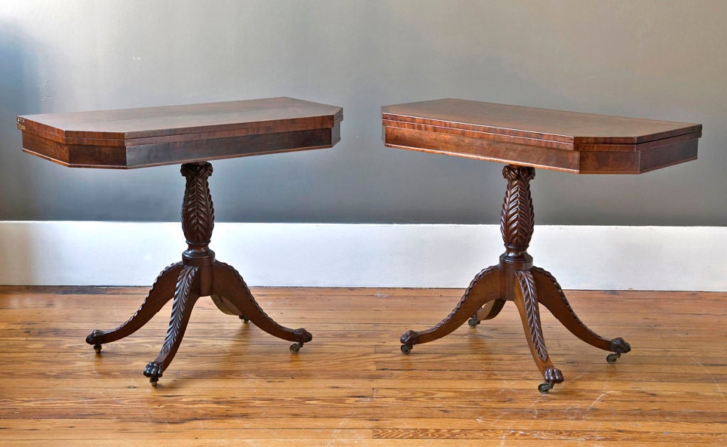 A fine pair of period flame mahogany card tables attributed to Duncan Phyfe.  The pivoting tops are supported by a center column carved with acanthus leaves.  The acanthus leaf design continues down the legs, each terminating in a hairy paw dog foot.