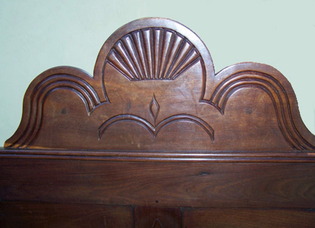 This Jamaican bed is sized proportionally to an adult bed and is held together by pegs, a clear sign of early Jamaican construction. The posts feature a series of turned sequential rings. The paneled headboard is bolted onto the back of the bed and