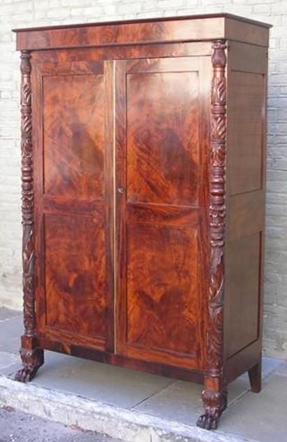American crotched Cuban mahogany linen press with carved acanthus leaf ending in lions paw feet. Possibly from Norfolk Virginia. From the Federal period