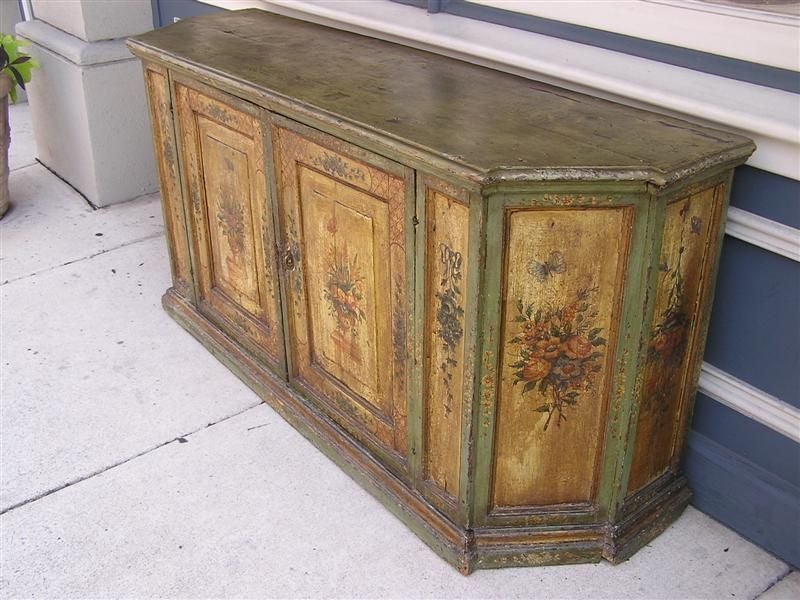 French faux painted console with two flanking hinged doors, exterior painted floral vases resting on columns with ribbon & butterfly motif, single interior shelf, and terminating on a molded edge base. All original.  Late 18th Century