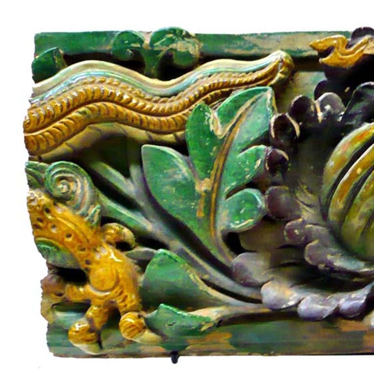 Pair of Ming Dynasty Period Glazed Earthenware Wall Tiles (1368-1644); in high relief and decorated with flora, fauna, and dragons. Raised on modern iron stands. 