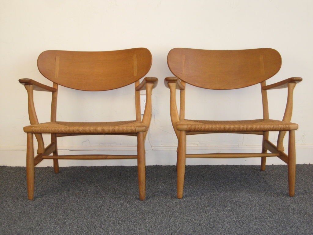 Stunning and mint example of the Ch-22 chair. These chairs are very impressive. They are wide and low with over exaggerated backs. The woven seats are original and perfect.