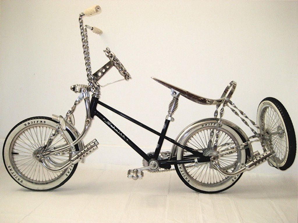 A vintage Schwinn custom lowrider.  After burners, spare tire, chain steering wheel, twisted chrome everywhere, white wall tires, rear view mirrors, 56 spoke wheels and so much style.  A true California bike, custom lowriders originated there at the