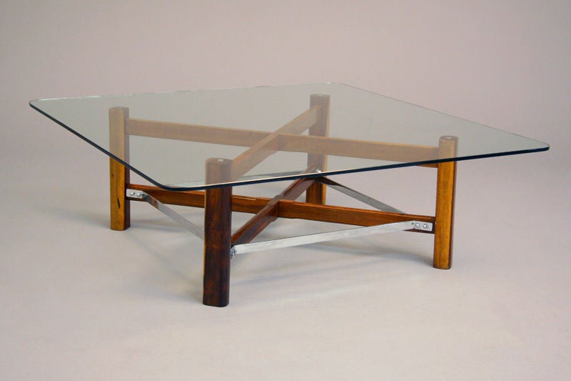 A square coffee table of solid Brazilian Rosewood with chrome supports and a glass top with polished edges. See matching side tables as well.

Beautifully refinished with a hand-rubbed French polish.  All items from Brazil are made of exotic