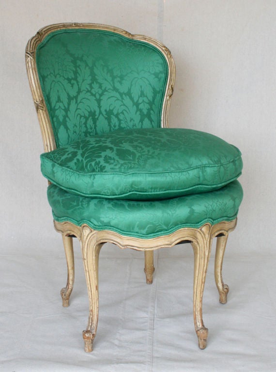 French five-legged small-scaled boudoir chair fashioned of carved wood with old paint covered in emerald green Scalamandre fabric and down cushion.