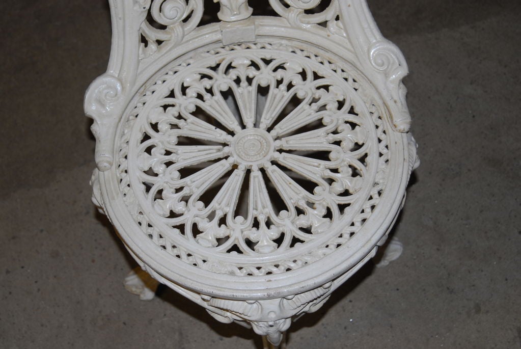 A finely cast iron and painted Victorian garden chair with central medallion back  with image of maiden