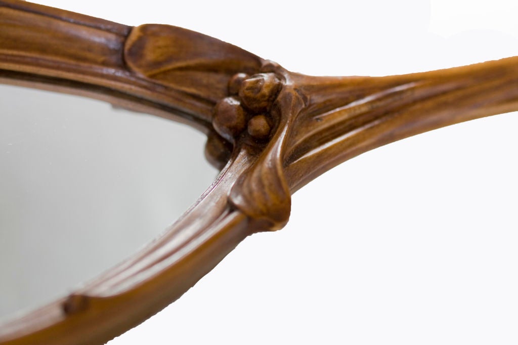 French Art Nouveau carved wood hand mirror with mistletoe decoration by Jules Cayette. Unsigned