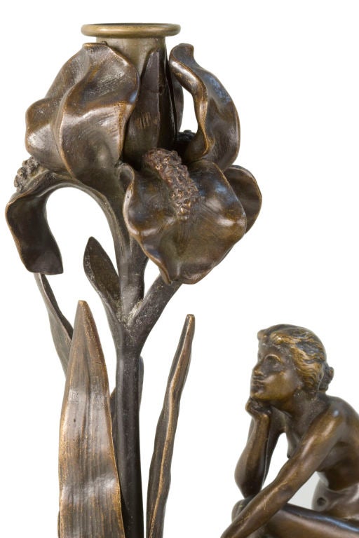French Art Nouveau bronze iris candlestick by Jozon, depicting a nude womanl sitting on a lily pad gazing towards the iris. It is signed, 