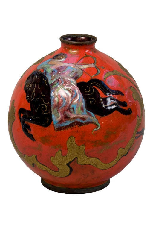 A French Art Nouveau enameled laid over copper vase by, Camille Fauré decorated with a stylized peacock and a woman on horseback shooting an arrow and further decorated with a stylized dee against an ox blood background with gold trailings. The vase