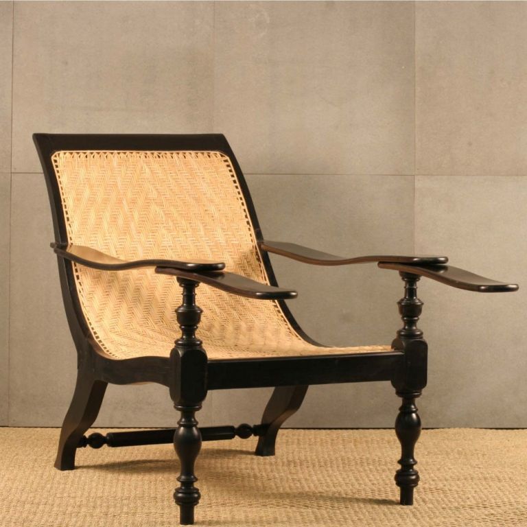 Anglo-Indian plantation chair made of solid ebony with newly caned chevron patterned seat. Slightly curved pivoting leg rests tuck under arms.<br />
Ebony is the densest, rarest and most valuable of all hardwoods.