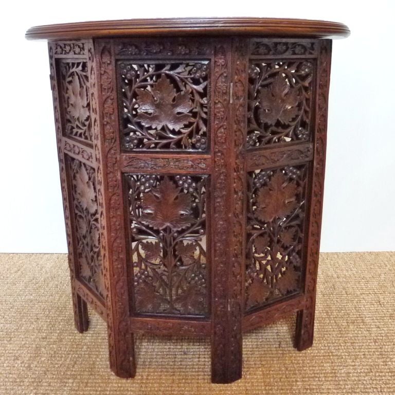 Anglo-Indian carved rosewood side table with folding base. Top has brass inlay in floral vine pattern. Tables such as these were used as end tables in palaces and large homes in Northern India. Table will be sold in restored condition.