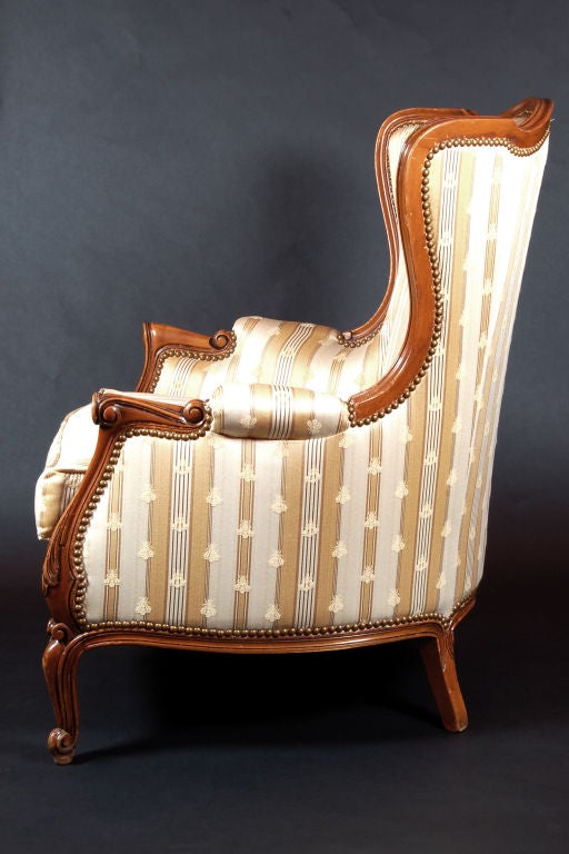 Beautiful pair of bergere chairs with Napoleonic bee upholstery and beautiful French carved frame with nailhead trim.