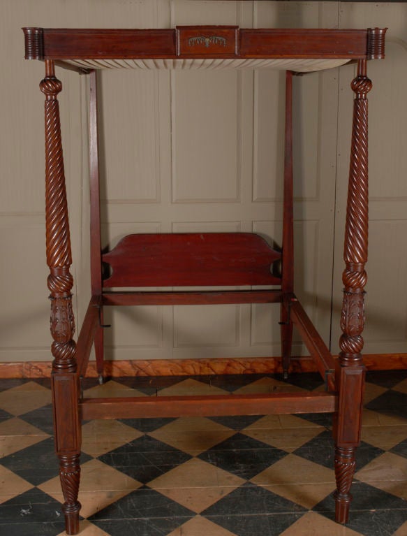 A very fine Sheraton carved mahogany bedstead with a paneled canopy, in the manner of Samuel F. McIntire, Salem, Massachusetts, circa 1815.  This important four post bed is richly decorated in a manner closely associated with the best carvers of