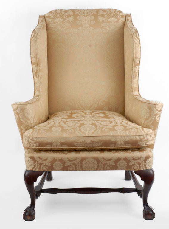 This wing chair exhibits appealing proportions together with boldly shaped cabriole legs, creating a handsome overall form, that is associated with Boston examples. The arched crest joins shaped wings which flow downward into rolled arms. These
