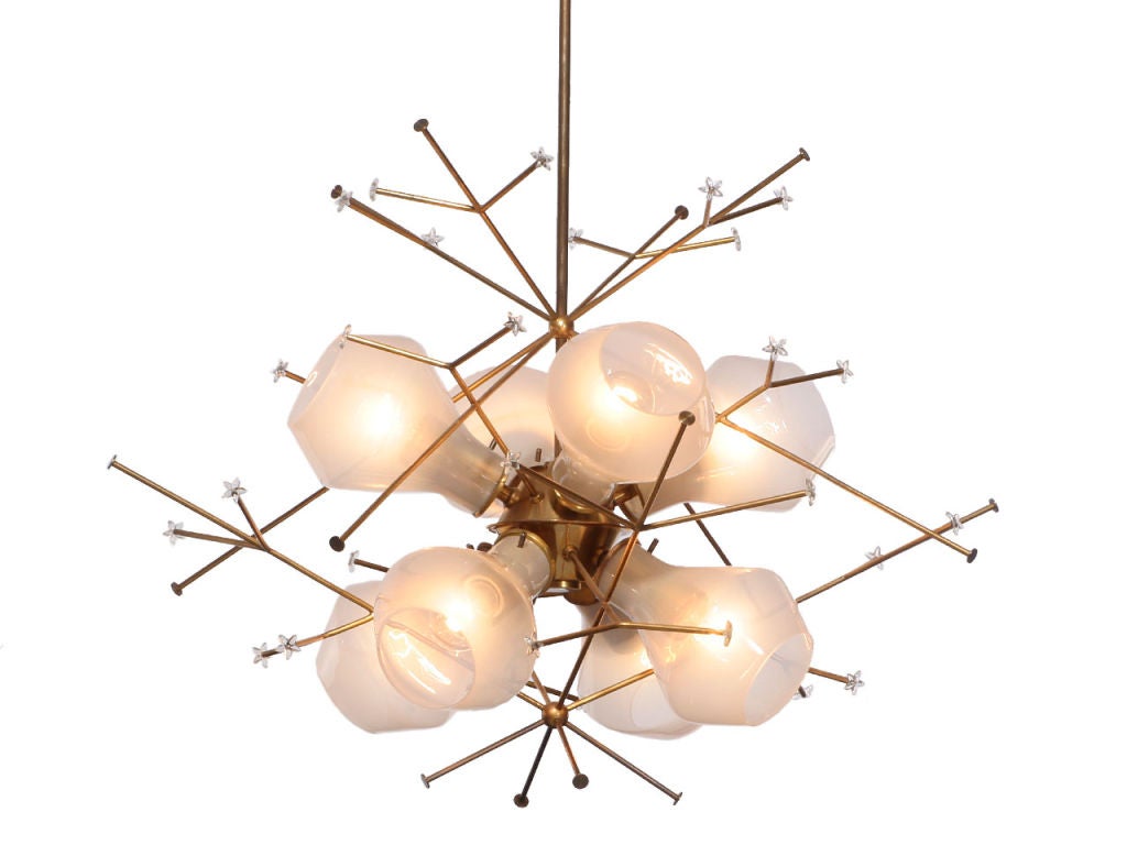 A brass snowflake ceiling fixture with eight translucent white glass shades. designed by Paavo Tynell made by TAITO OY