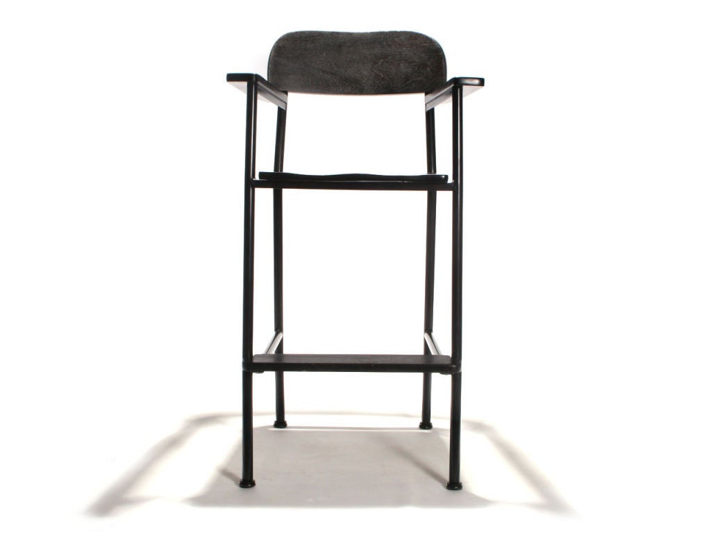 A custom height WYETH billiard stool with wood seat, back, arms and footrest, on a tubular steel frame.