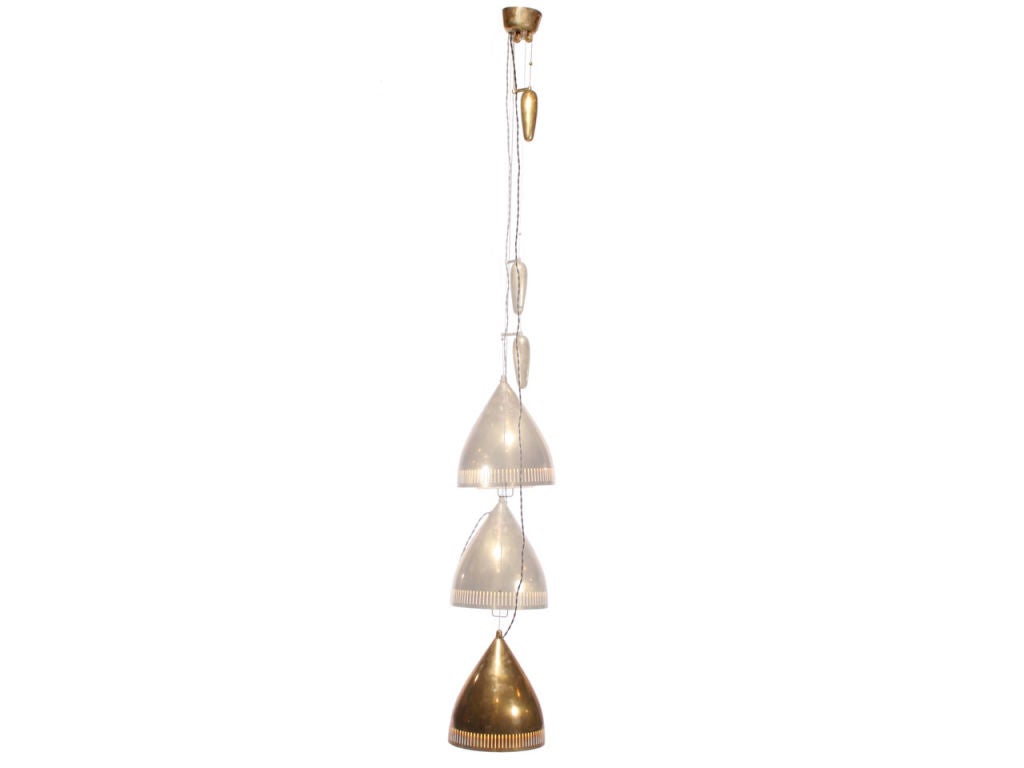 A brass pull-down ceiling fixture with a slit-pierced bullet-form shade and brass counterweight designed by Paavo Tynell made by TAITO OY FINLAND