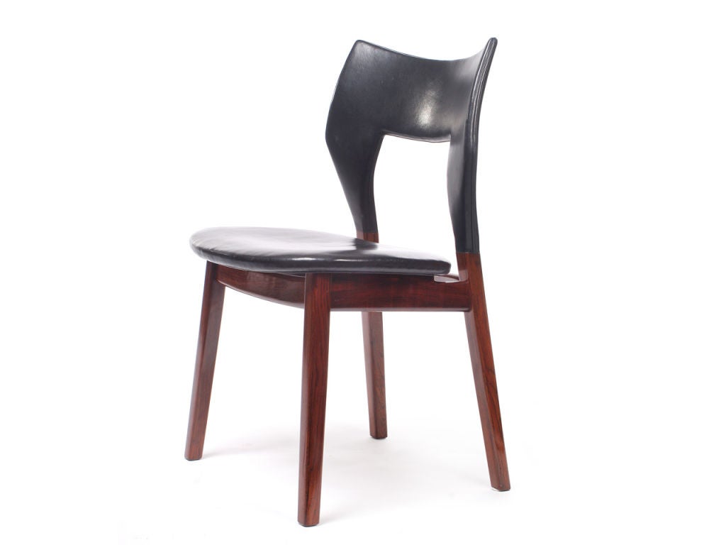 A rosewood dining chair and leather chair by famed Danish designers Edward and Tove Kindt-Larsen. Each chair features solid rosewood frame with the original black oxhide leather seat and back, finished underseat with brass hardware.
Crafted in