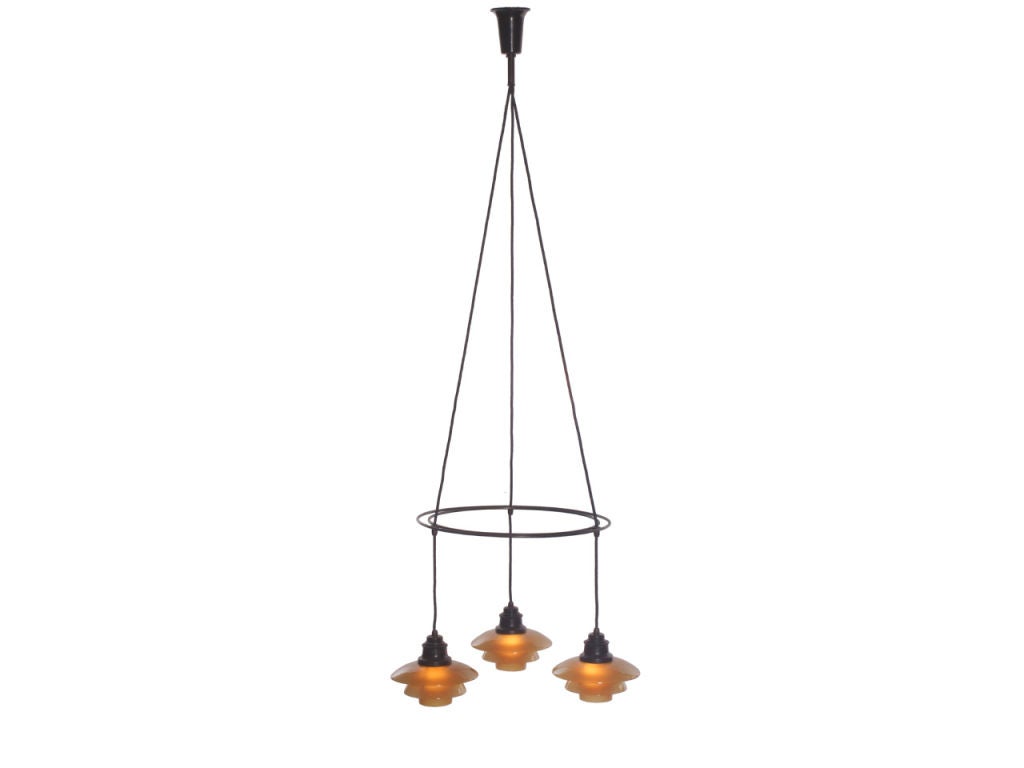 A “doubleringkrone” ceiling lamp with a patinated bronze double ring spacer supporting three lamps, each with three amber glass shades designed by Poul Henningsen made by Poulsen