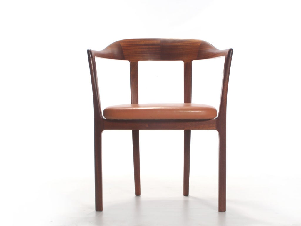 A mahogany armchair with a graceful curved back and leather seat. 1958 Design by Ole Wanscher cabinetmaker A.J. Iversen