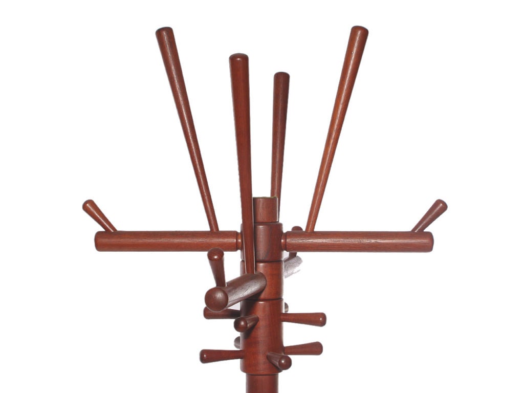 An elaborate hat and coat tree with sculptural turned teak tapered dowel posts on an x-form base.