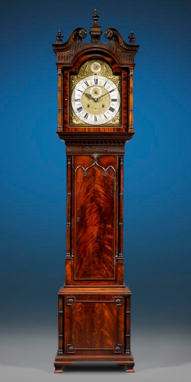 Exquisite and beautifully designed, this marvelous mahogany clock was crafted by John Hebert in the elaborate Chinese Chippendale style. A study in symmetry and balance, the case is inlaid with crotch mahogany and incorporates outstanding design
