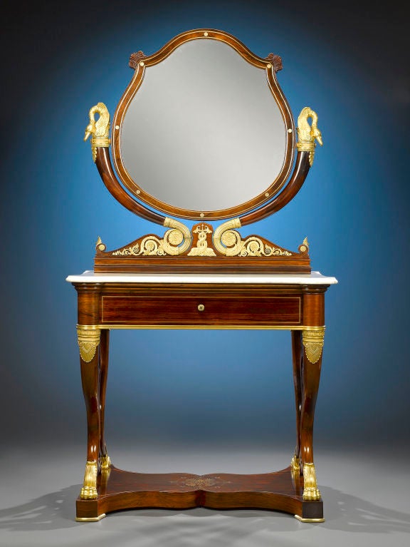 This rare and stunning French double dressing table is exquisitely built in a timeless design. Crafted of luxurious rosewood, this elegant vanity exhibits the bold yet classical Empire style, incorporating iconic elements such as hand-chased bronze