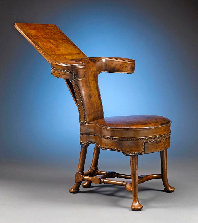 This splendid George II-period reading/cockfighting chair is stunning in both form and quality. Crafted of rare walnut, the marks of an early Georgian piece, this intriguing leather-upholstered seat features a yoke-shaped toprail with an adjustable