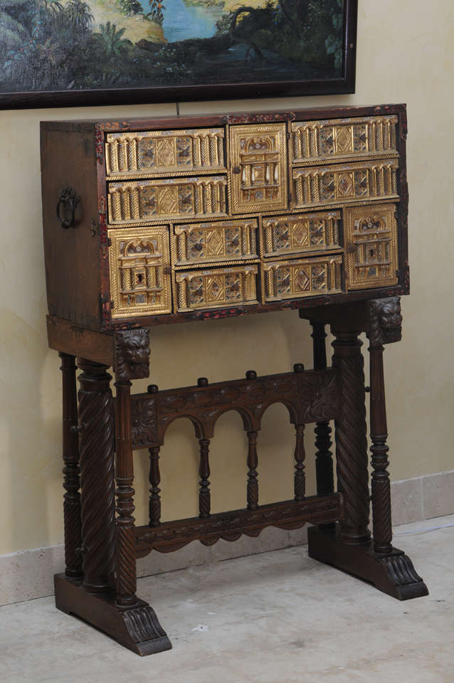 A Spanish 17th/18th CenturyVargueno ,resting on a later stand.The interior divided into an intricate arrangement of drawers and recesses'having inlaid carved bone,beautifully gilded and intricately hand painted with a very slight delicate floral