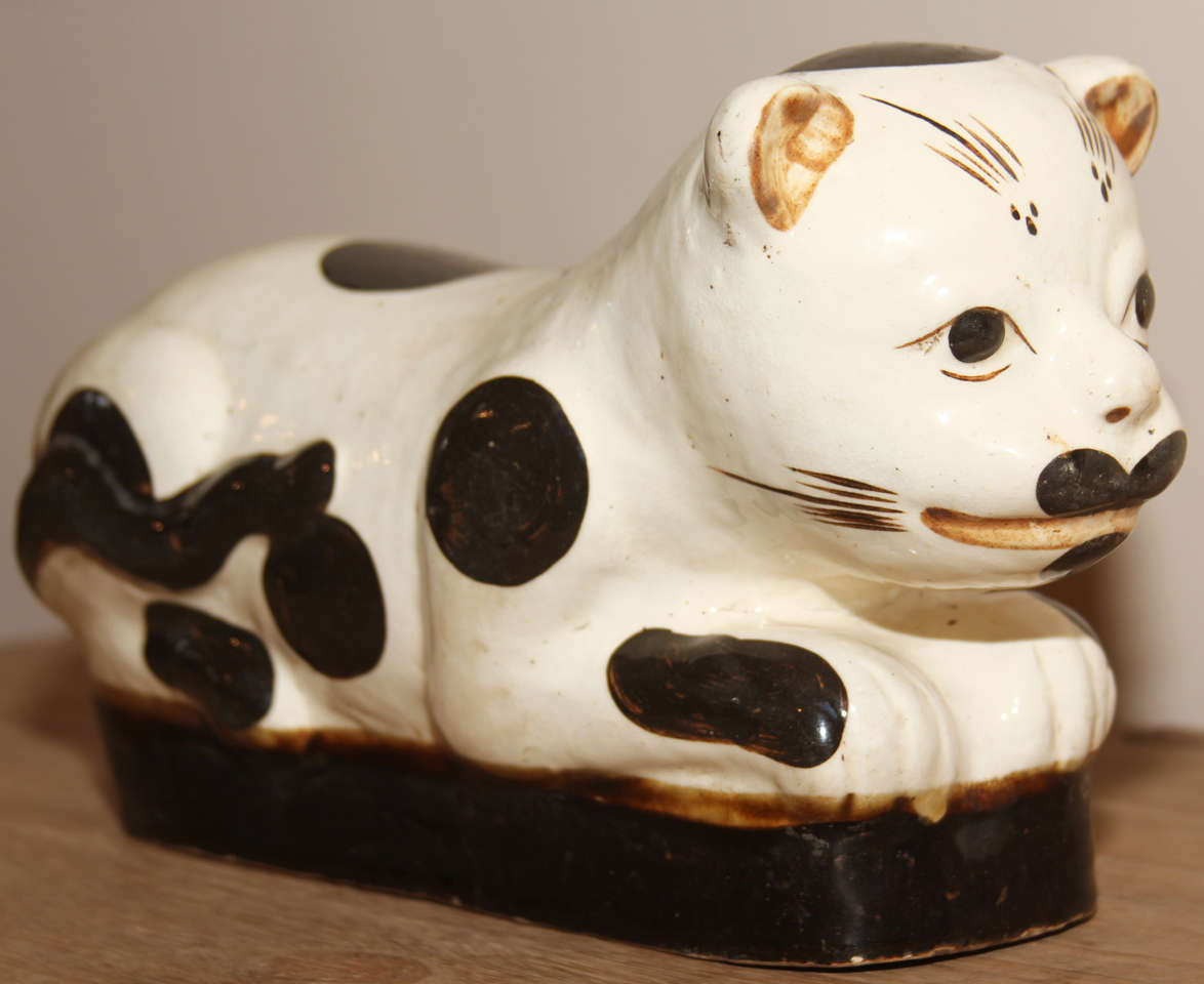 A Chinese porcelain cat-form headrest or pillow. The cat is decorated in iron oxide spots. Originally used with a padded cushion pillow, as in this example, to keep elaborate hairdos intact while one slept.
Late 19th century
7½