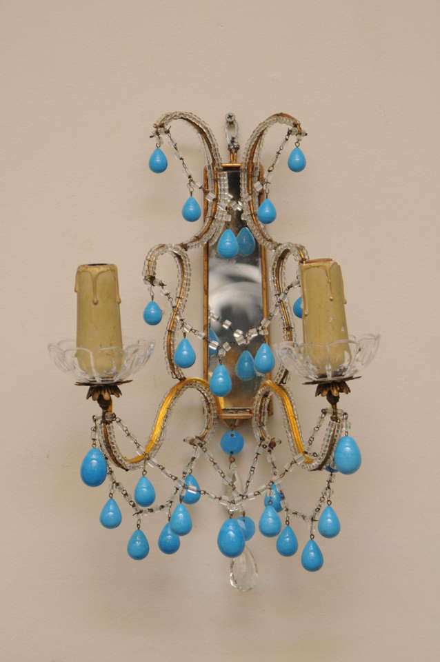 Pair of Sconces, each having a rectangular mirrored backplate of gilded iron affixed with glass beads; S-scroll ornament surmounts two candlearms finished by scalloped bobeches and lights, clear faceted crystal and turquoise drops adorn each sconce;