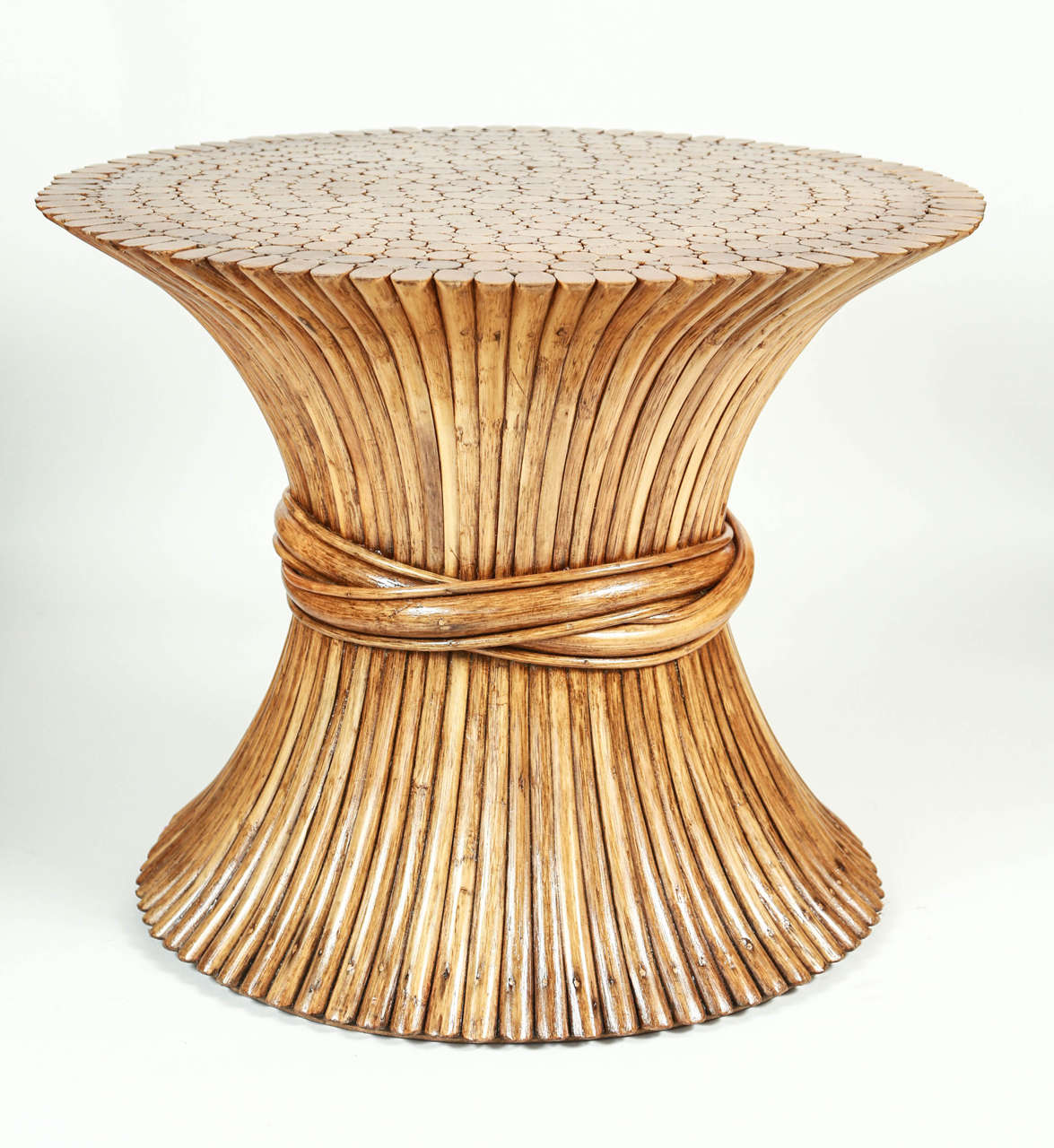 Mid-Century table of rattan bundled together resembling a sheath of wheat. Has been cleaned and new lacquer finish.