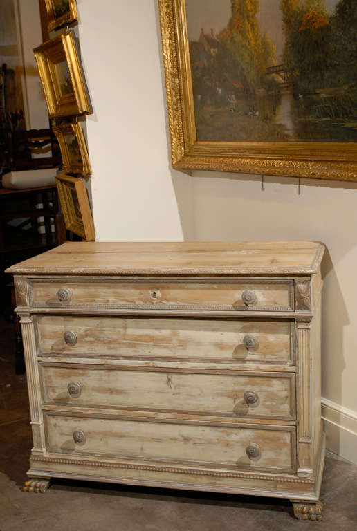 An early 19th century Italian neoclassical four-drawer commode featuring a two-plank rectangular molded top and a cornice nicely carved with a foliage pattern. Fluted and reeded pilasters with capitals support the overhanging narrower frieze drawer