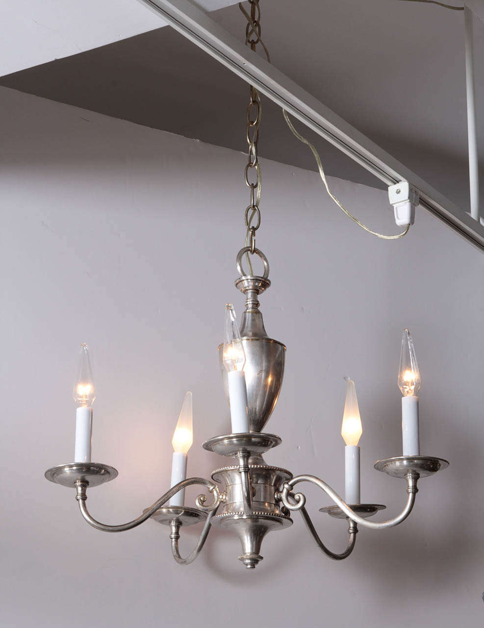 Tradition silver plate chandelier with five arms.  England, circa 1920.  Rewired for U.S. use; takes five candelabra base bulbs, 60 watts max each.

Includes canopy and hanging chain. Measures 20 inches wide x 18 inches tall.