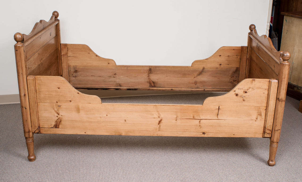 Un beau lit à caisson en pin avec tête et pied de lit festonnés:: épis de faîtage tournés et côtés galbés.  Cette pièce nécessite un matelas sur mesure.