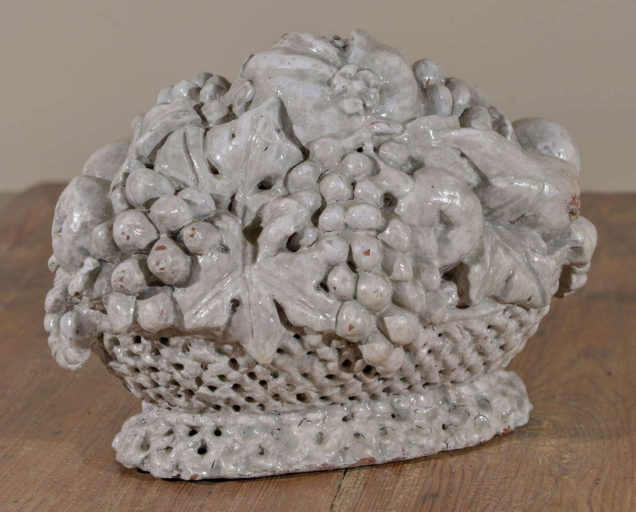 19th century tin glazed terracotta fruit in basket, from Vernusse, France.