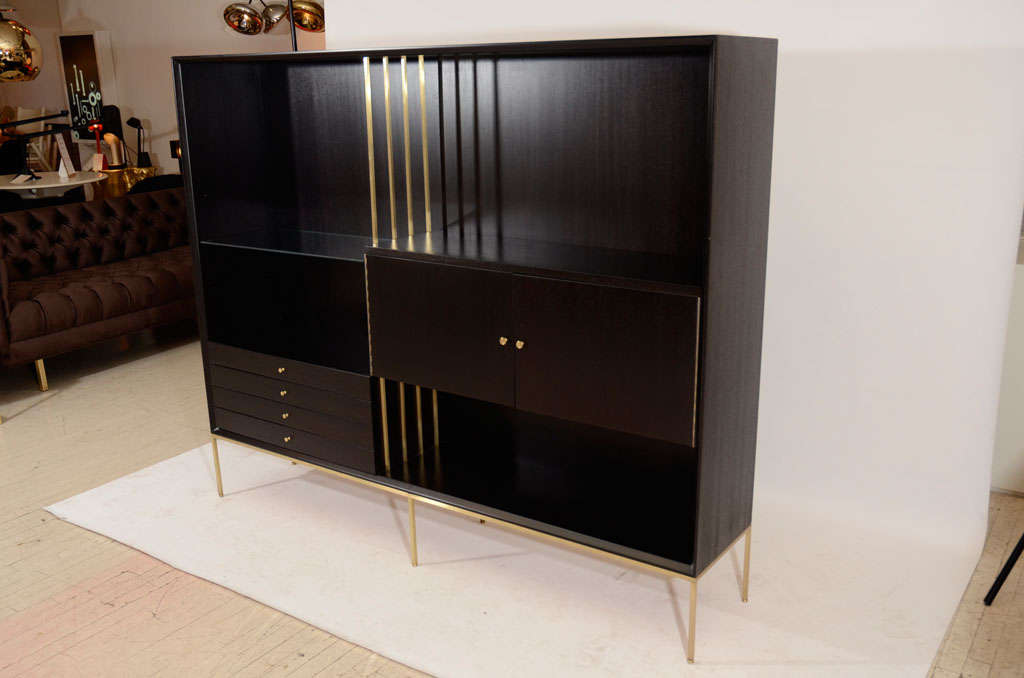 Very handsome display cabinet or room divider by Paul McCobb. Finished in a dark mahogany stain with brass accents and a brass stand. Please contact for location.