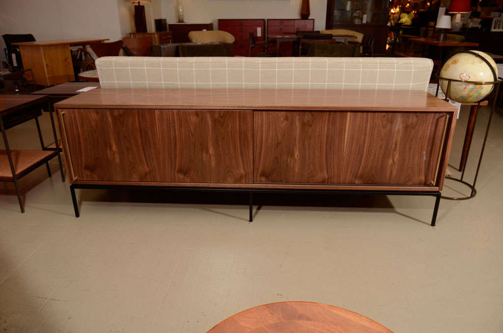 Walnut credenza with sliding doors on black powder coat base. Available with brass or painted handles. Custom sizes and finishes available.