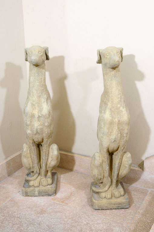 Pair of Well Patinated Garden Statues in the Form of English Whippets in Seated Position.  England, 20th Century<br />
<br />
7 inches wide x 8 inches deep x 30 inches high