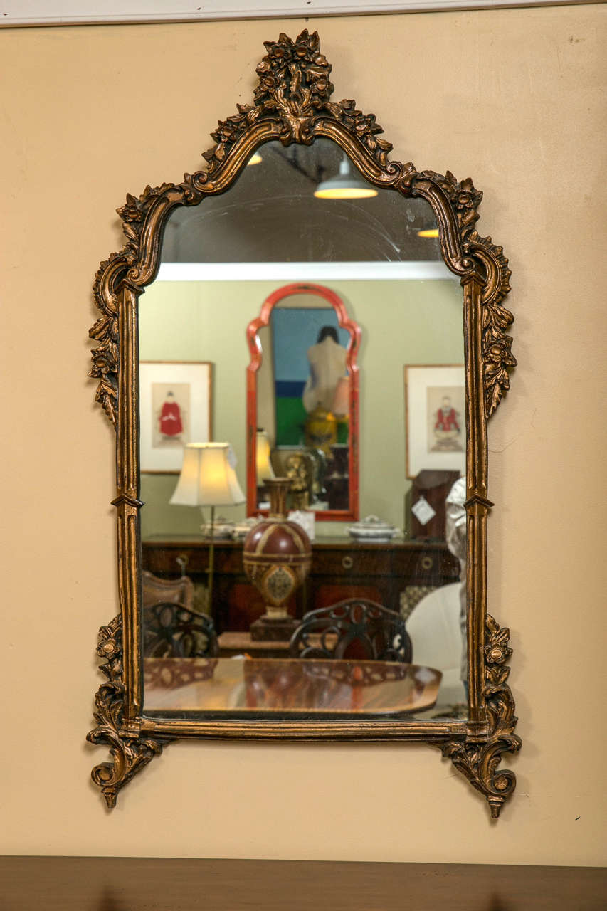 Pair of Louis XVI style mirrors in gilt gold finish. A nice pair of decorative mirrors in the Louis XV style taste each having carved rosette Rococo frame of rectangular form. Weathered to appear as if they are from the early 19 century.