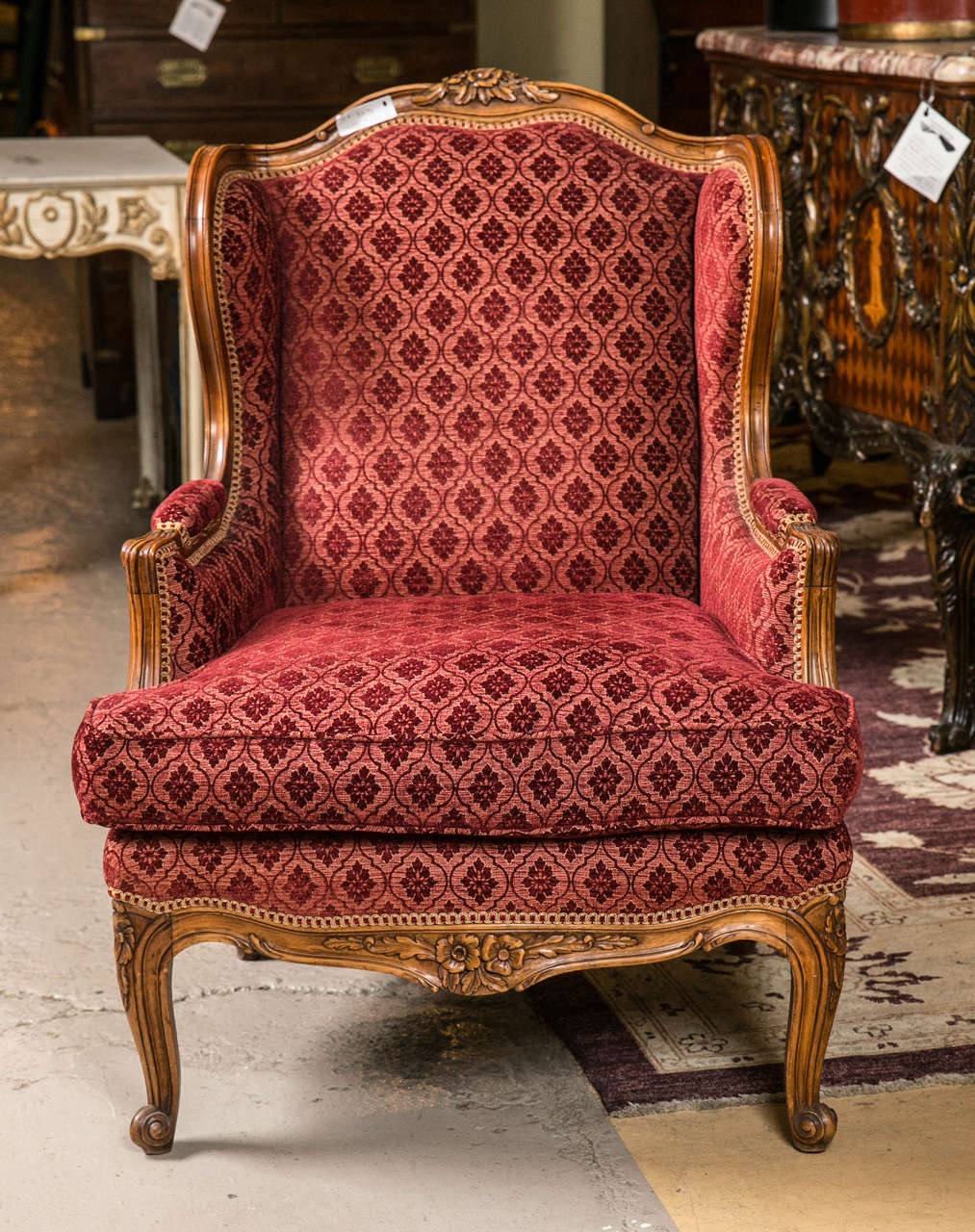 Pair of Louis XV style French bergere chairs. Very finely carved and crafted pair of wingback chairs in the Louis XV fashion. The carved cabriole legs leading to a finely detailed rosette carved apron and upper design. The flowing walnut wood