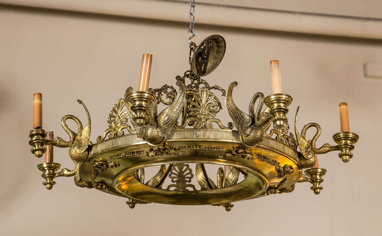 19th century doré bronze figural chandelier. Finely crafted doré bronze circular chandelier of Empire form. Having eight arms of detailed and finely gilt winged full bodied swans holding the lights from the tip of each beak.
