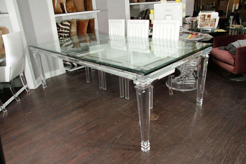 Glass top dining table with banded Lucite legs. Customization is available in different sizes and glass colors.