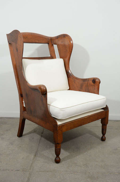Pair of wood wing back chairs with cushions from the late 19th century. Price is for the pair.