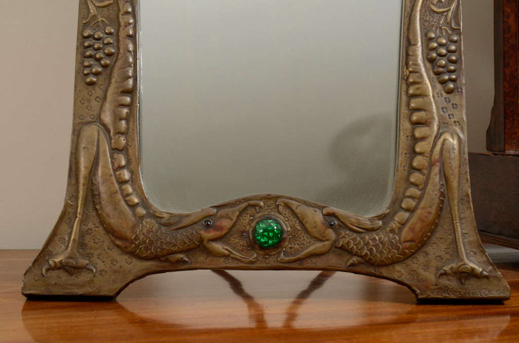 Beautiful and large Unusual Art Nouveau Mirror, signed F. Rochard 1911, with 3 glass jewels (2 red and large green)  The small red glass jewels are in the eyes of the reptiles on the bottom of the mirror. The reptiles appear to be  eating the green