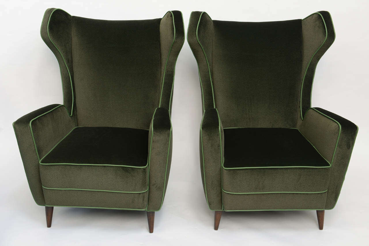 Rich deep green velvet and leather piping, these very unique ample and comfortable armchairs are restored to perfection.