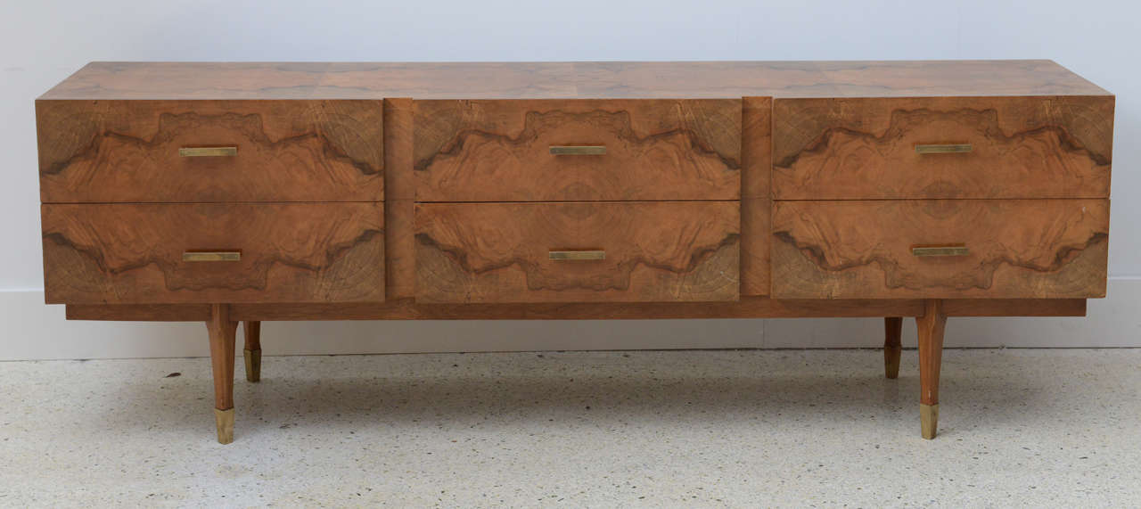 All-over in exotic root wood veneers, comprising six drawers over tapering legs terminating in brass caps.
This piece relates to the root wood pieces illustrated in Ugo de la Pietra's book on Gio Ponti where he used exotic root wood veneers like