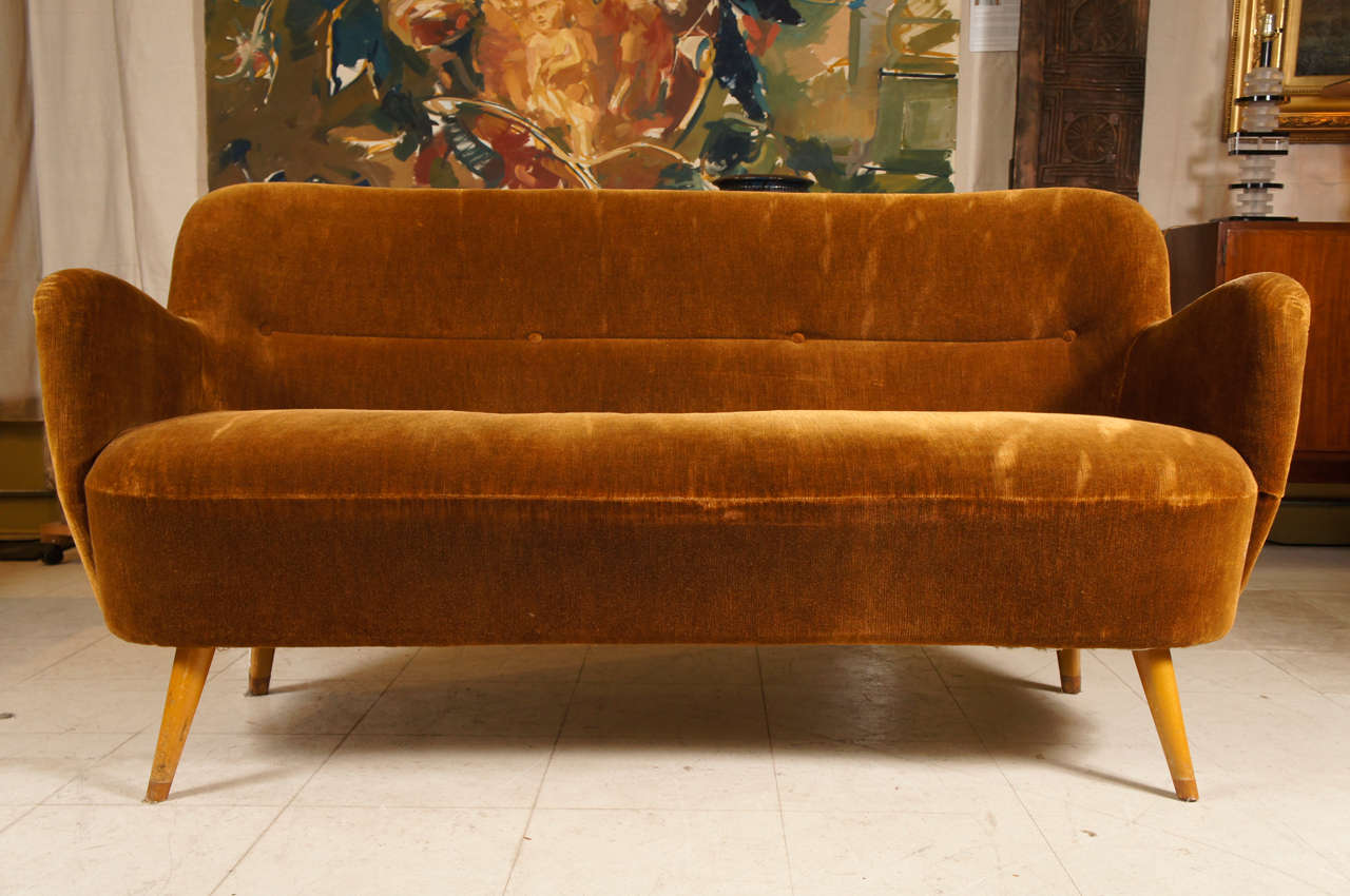 This curved and stylish sofa covered in gold mohair is attributed to Gio Ponti and was most likely part of the furnishings from an Italian luxury cruise liner commissioned in the 1960's.